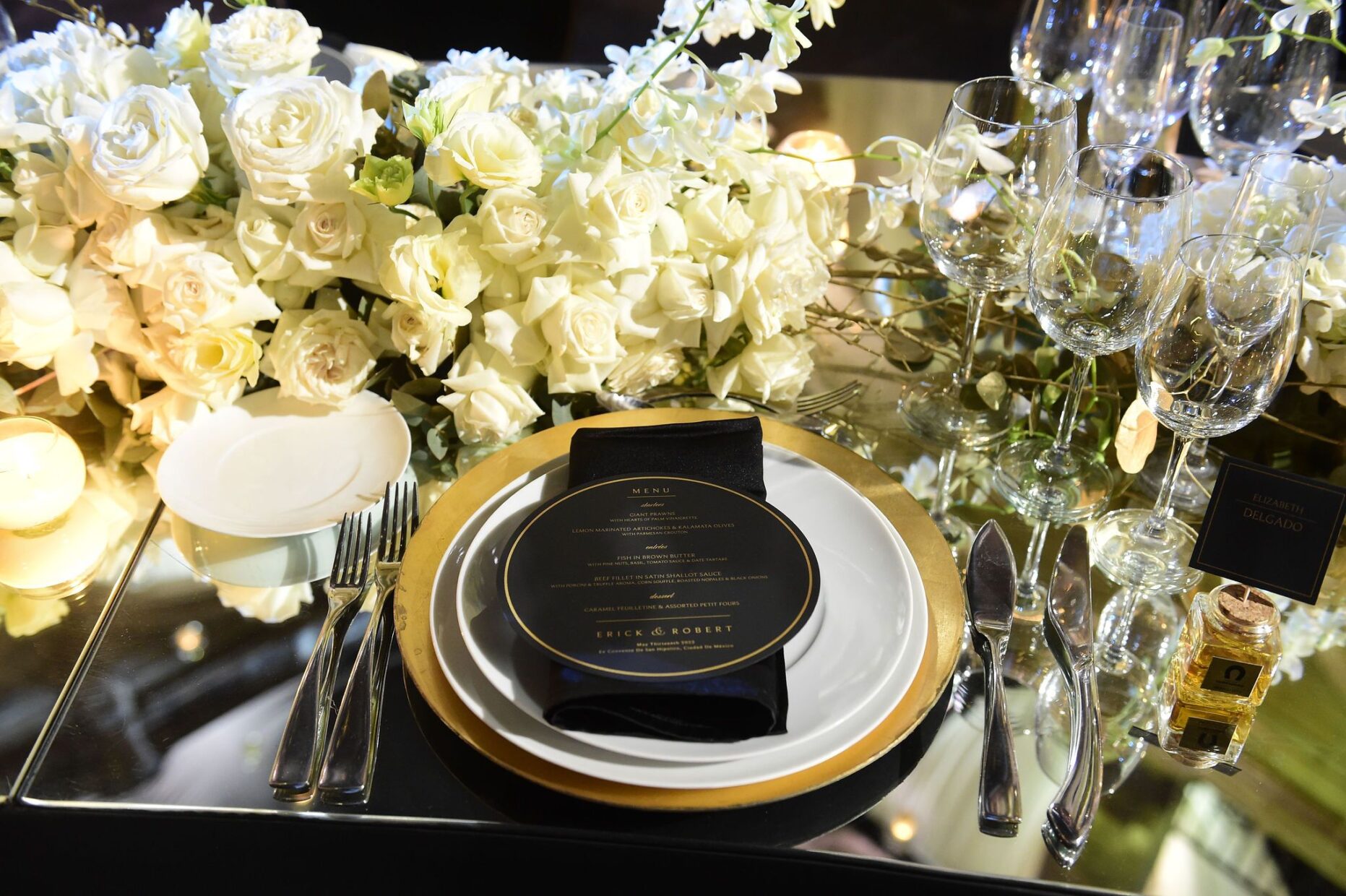 Table setting with porcelain plate and black and gold menu.