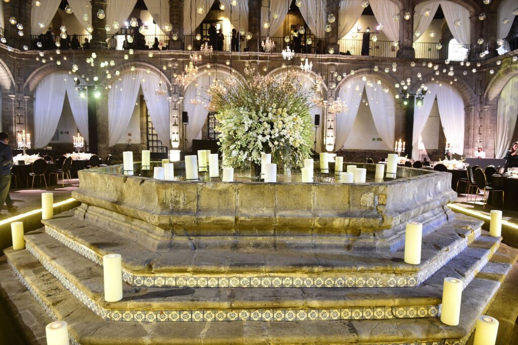 concrete fountain with a floral center piece and candles on the steps