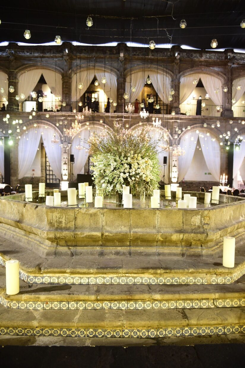 Center fountain with giant floral arrangement in the center in low lighting