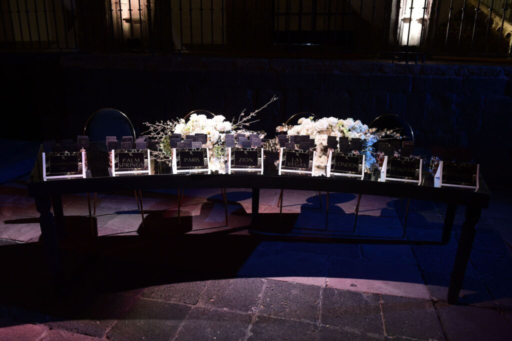 Guest table seating table in dim lighting and white rose floral arrangements
